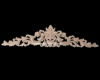 May include: A carved wooden decorative architectural element with a symmetrical floral and leaf design. The piece is light-colored and features intricate details, including flowers and scrolling leaves. The background is black.