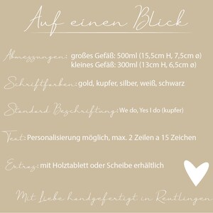 May include: A white text graphic on a beige background with the text "Auf einen Blick" (German for "At a glance"). The graphic lists the dimensions of two sizes of glass jars, the available font colors, the standard text, and the option to personalize the text. The graphic also mentions that the jars are handmade in Reutlingen, Germany.