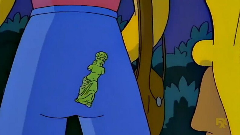 Puede incluir: Un par de pantalones vaqueros azules con una estatua de mujer de pl&aacute;stico verde unida al bolsillo trasero.