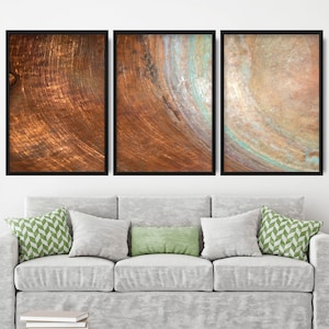 Pode incluir: Três impressões de arte abstrata emolduradas com um esquema de cores cobre e marrom. As impressões apresentam um padrão de textura e redemoinho.