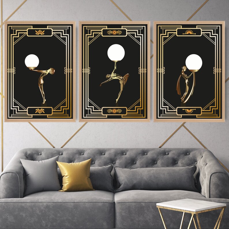 K&ouml;nnte beinhalten: Drei gerahmte Kunstdrucke mit schwarzem Hintergrund und goldenen Akzenten. Jeder Druck zeigt eine stilisierte Figur, die eine Gl&uuml;hbirne h&auml;lt. Die Figuren befinden sich in einer Tanzpose.