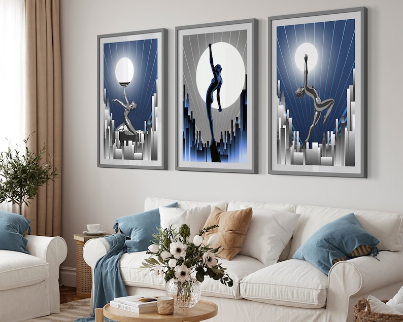 May include: Three framed art prints with a blue and silver color scheme. Each print features a stylized silhouette of a woman dancing against a backdrop of a city skyline and a large moon.