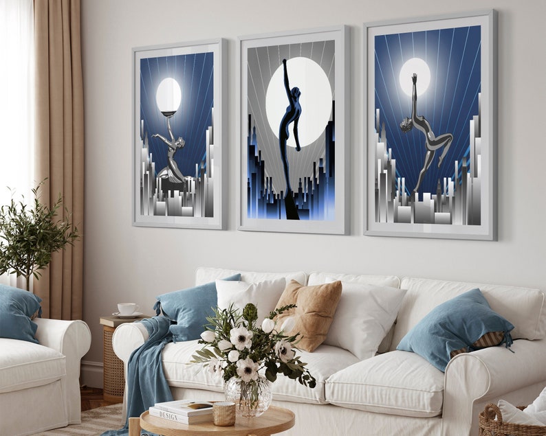 May include: Three framed art prints with a blue and silver color scheme. Each print features a stylized silhouette of a woman in a city setting with a large moon in the background.