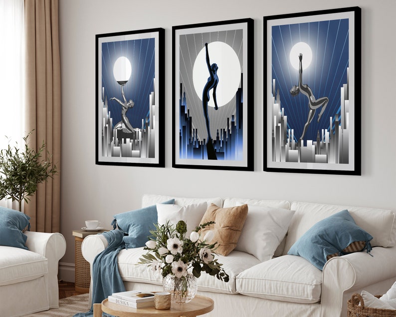 May include: Three framed art prints with a blue and silver color scheme. Each print features a stylized silhouette of a person dancing against a backdrop of a city skyline and a large moon.