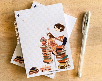 Könnte beinhalten: Illustration einer lesenden Person, umgeben von Bücherstapeln, auf kariertem Papier. Ein weißer Stift liegt neben dem Papier. Die Illustration zeigt warme Farben und den Text "@mei_illustrations".