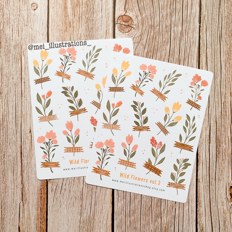 May include: Two sticker sheets featuring floral designs with orange, peach, and green flowers, accented with brown tape. The text "Wild Flowers vol. 3" and a website address are printed on the stickers. The artist's Instagram handle is also visible.