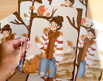 May include: Illustration prints featuring a cartoon character in fall attire, surrounded by pumpkins and autumn leaves. The character wears a striped sweater, scarf, and glasses. The prints also include images of hedgehogs and trees.