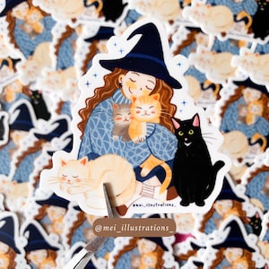 Peut inclure: Autocollant avec une illustration de dessin animé d'une personne portant un chapeau de sorcière et tenant deux chats orange et gris. Un chat noir est assis à côté, et un chat crème dort en bas. Le nom de l'artiste est visible.