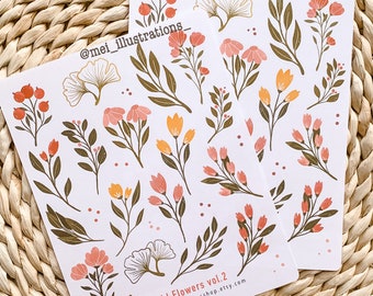 May include: Two sheets of stickers featuring floral illustrations. The designs include various flowers, leaves, and berries in shades of peach, orange, and gold, with dark green stems. The text "Wild Flowers vol. 2" and a website address are printed on the bottom.