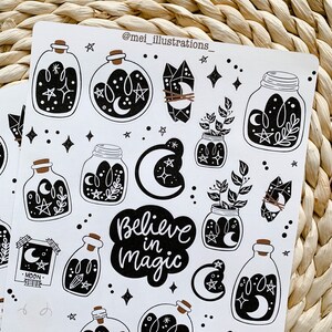 May include: White sticker sheet featuring black illustrations of potion bottles, crystals, jars with plants, moons, stars, and the phrase "Believe in Magic." The sticker sheet has a whimsical, celestial theme.