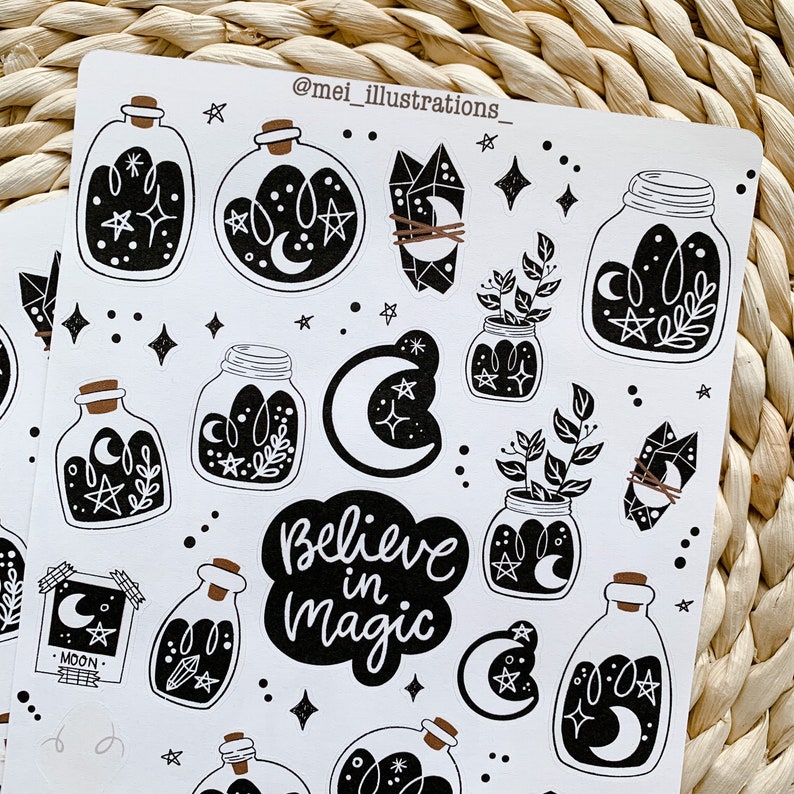May include: White sticker sheet featuring black illustrations of potion bottles, crystals, jars with plants, moons, stars, and the phrase "Believe in Magic." The sticker sheet has a whimsical, celestial theme.