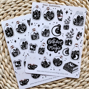 May include: Two sheets of white stickers featuring black and white illustrations of potion bottles, moons, stars, crystals, and the phrase "Believe in Magic." The stickers have a whimsical, celestial theme.