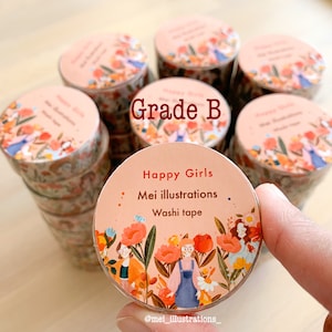 May include: A collection of washi tape rolls featuring a floral and girl illustration. The tape rolls are peach-toned and display the text "Happy Girls, Mei illustrations, Washi tape". The text "Grade B" is also visible.