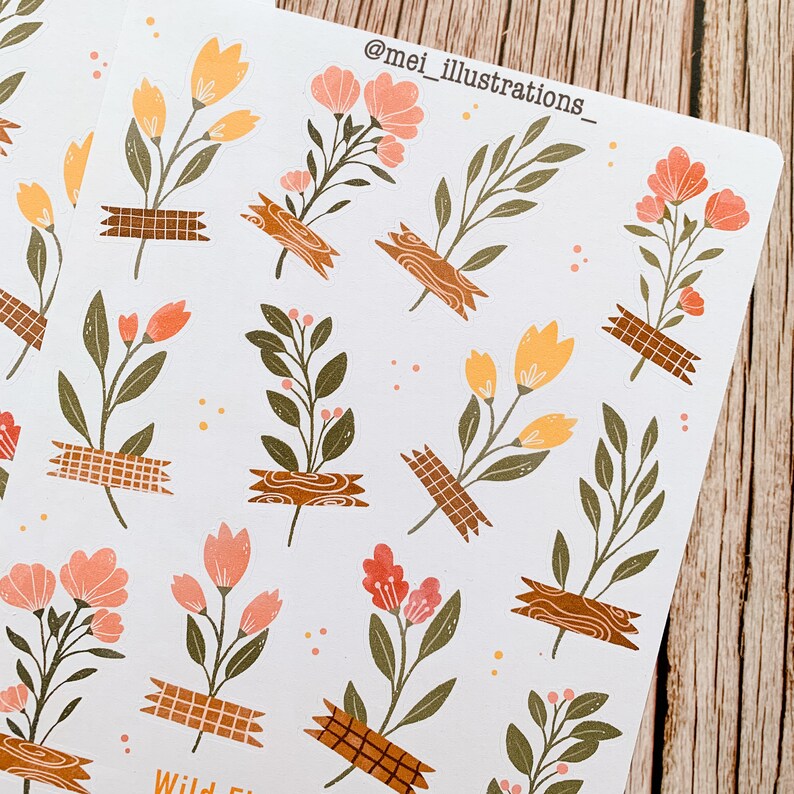 May include: Sheets of floral stickers featuring various flower and leaf designs in shades of peach, yellow, and green. The floral elements are affixed with brown tape. The text "@mei_illustrations_" is visible at the top. The stickers are on a white background.
