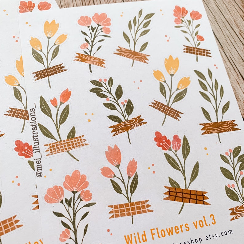 May include: Sheets of stickers featuring floral illustrations in shades of peach, yellow, and green. The flowers are affixed with brown tape. The text "Wild Flowers vol. 3" and a shop URL are visible.