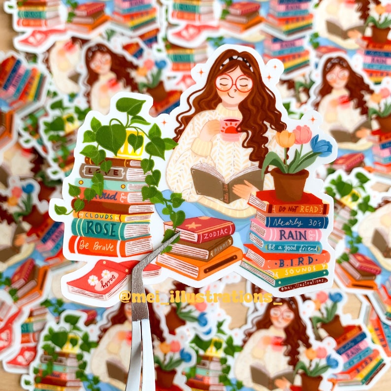 May include: A selection of stickers depicting a woman reading, surrounded by books, plants, and a cup of tea. The stickers showcase colourful book spines with text such as "Clouds", "Rose", and "Zodiac". The artist's name, "@meillustrators", is also visible.