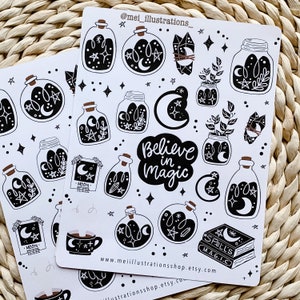 May include: Two sticker sheets featuring black and white illustrations of potion bottles, moons, stars, crystals, and the phrase "Believe in Magic." Additional designs include a teacup and a book labeled "Spell's M.A.G.I.C."