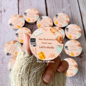 May include: A collection of washi tape rolls with a study theme. The central roll features illustrations of books, a laptop, and the text "Mei illustrations, Washi tape, Let's study." The rolls are primarily peach and white.