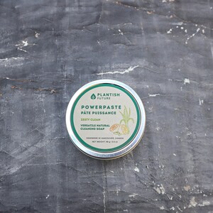 May include: A round metal tin of Plantish Future Powerpaste cleaning soap. The label is green and white with text reading Powerpaste, P&acirc;te Puissance, Zesty Clean, Versatile Natural Cleaning Soap, and a net weight of 89 g / 3.5 oz.