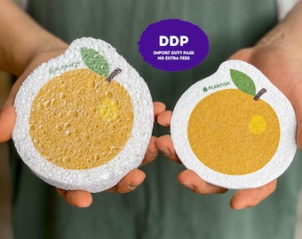 May include: Two round, textured cleaning sponges shaped like oranges, featuring a white border, a yellow-orange center, and a small green leaf. The word PLANTISH is printed on each sponge. A purple circular graphic displays the text DDP IMPORT DUTY PAID NO EXTRA FEES.
