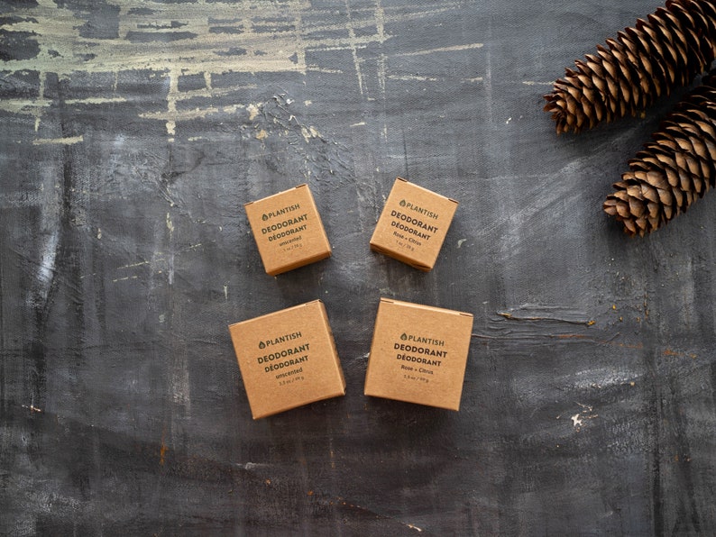 Puede incluir: Cuatro cajas cuadradas de cart&oacute;n de desodorante Plantish en dos tama&ntilde;os. Dos cajas peque&ntilde;as marcadas con 1 oz / 28 g y dos cajas grandes con 2,5 oz / 70 g. Las etiquetas incluyen el texto DEODORANT D&Eacute;ODORANT y especifican los aromas indicados.