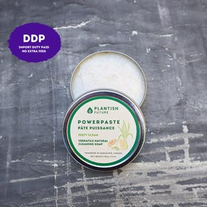 May include: A round metal tin containing Plantish Future Powerpaste cleaning soap. The label features green text, a leaf icon, and citrus illustrations. It states Zesty Clean, Versatile Natural Cleaning Soap, and Net Weight 98 g / 3.5 oz.