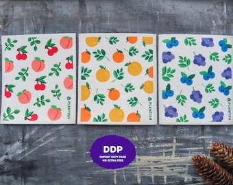 May include: Three rectangular cleaning cloths with a light beige background. The first features red cherries and pink peaches with green leaves. The second shows orange citrus fruits with green leaves. The third displays blue and purple berries with green leaves. Each cloth has the text PLANTISH printed vertically.
