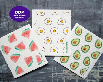 May include: Three rectangular Swedish dishcloths featuring repeating patterns of watermelon slices, fried eggs, and avocados. Each cloth is white with a textured surface and includes the green text PLANTISH printed along the side edge.