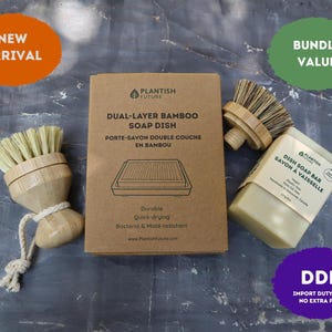 May include: A Plantish Future set including a dual-layer bamboo soap dish in a brown cardboard box, two bamboo dish brushes with light-colored bristles, and a rectangular dish soap bar with a label reading Dish Soap Bar Savon à Vaisselle.