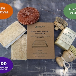 May include: A kitchen cleaning set including a copper scouring pad, two rectangular loofah sponges, a box labeled Dual-Layer Bamboo Soap Dish, a bar of dish soap, and two wooden scrub brushes with light-colored bristles and a cotton rope loop.
