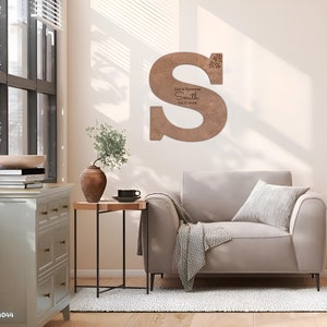 May include: A wooden letter S with a rustic finish. The letter is decorated with a snowflake design and personalized with the text "Lisa & Hermann Smith 04.17.2024".