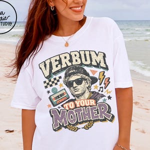 May include: White t-shirt with a graphic design featuring the text "VERBUM TO YOUR MOTHER" and an illustration of a bust wearing sunglasses and a cap. The design includes a cassette tape, lightning bolts, and stars.