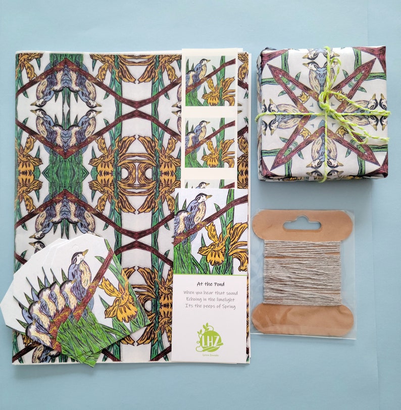 Shown Above: A set of wrapping tissue paper with a repeating pattern of blue birds and iris flowers. The paper is white with green, brown, and yellow accents. The paper is packaged with a matching gift tag and twine. The gift tag has a bird and flower design and the poem "At the Pond, When you hear that sound, Echoing in the limelight, Its the peeps of Spring."