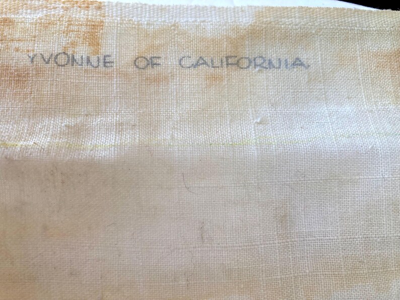 May include: A white fabric with the text "Yvonne of California" printed in black ink.