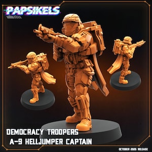 May include: Three orange-colored Democracy Troopers A-9 Helljumper Captain figurines. The figures are in a combat stance, holding rifles, and wearing detailed armor. The figures are on black circular bases. The text "Papsikels" and "October 2025 Release" are visible.