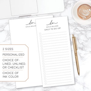 May include: Two blank white notepads with a checklist design. The top notepad has the text "KAYLA WILLIAMS DAILY TO DO LIST" and the bottom notepad has the text "KAYLA WILLIAMS". The notepads are on a white marble surface with a gold pen.