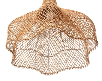 May include: A woven rattan pendant light fixture. The light fixture has a natural, light brown color and a unique, open weave design. The shade has a scalloped edge and is suspended from a natural fiber cord. The light bulb is visible inside the shade.