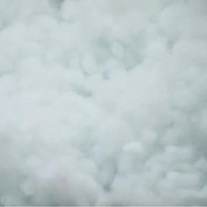 May include: A close-up of a white, foamy texture. The texture is soft and fluffy, resembling clouds.