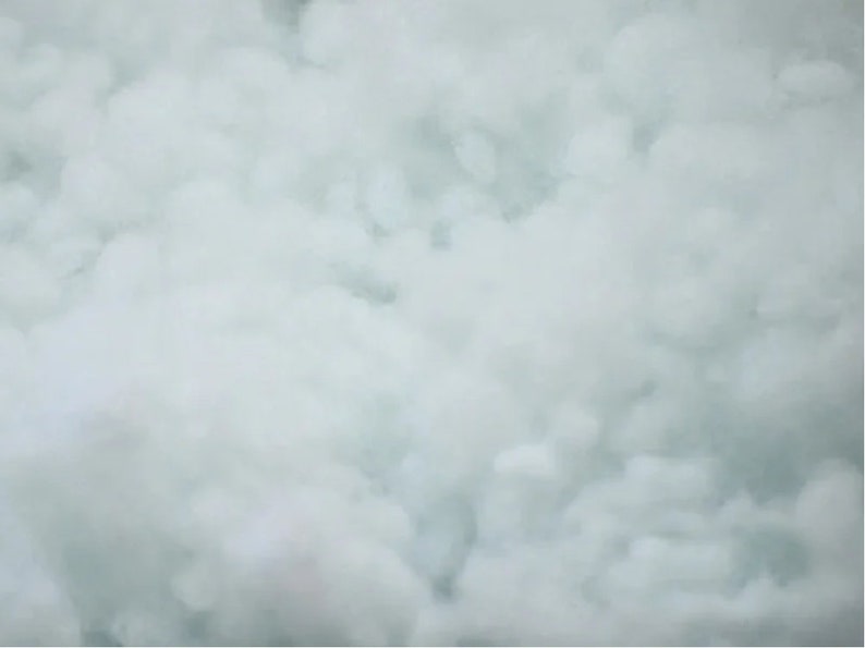 May include: A close-up of a white, foamy texture. The texture is soft and fluffy, resembling clouds.