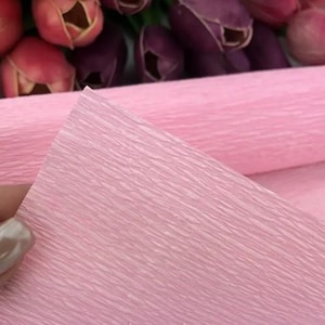 Soft pastel crepe paper rolls in dusty rose, peach, sage green and light blue arranged neatly together