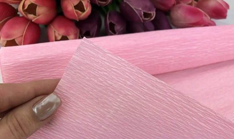 Soft pastel crepe paper rolls in dusty rose, peach, sage green and light blue arranged neatly together