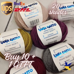 Peut inclure: Plusieurs pelotes de laine Lana Gatto Maxi Soft de différentes couleurs, dont rose, jaune, violet et gris. Chaque pelote porte une étiquette avec le nom de la marque et les détails du produit. Le texte "20+ nuances" et "Achetez 10 + 1 CADEAU" est également visible.