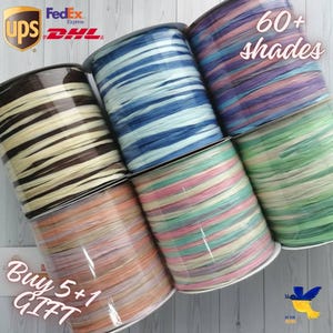 Può includere: Una collezione di rocchetti di nastro decorativo in vari colori, tra cui marrone, blu, rosa e verde. L'immagine include il testo "60+ sfumature" e "Acquista 5+1 REGALO". Sono visibili anche i loghi di UPS, FedEx e DHL.