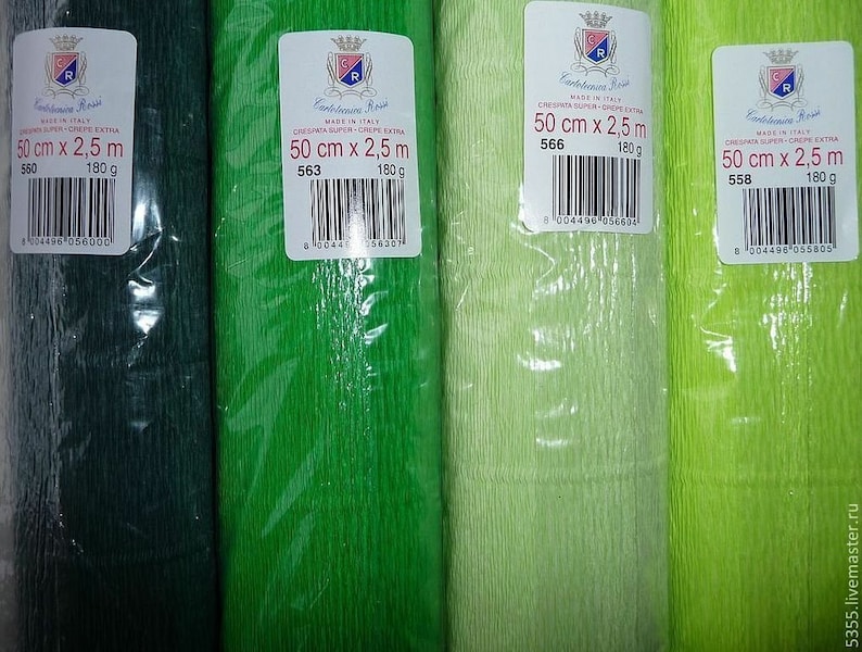 May include: Four rolls of Cartotecnica Rossi crepe paper in varying shades of green, from dark forest to bright lime. Each roll is wrapped in clear plastic and features a white label with the text 50 cm x 2.5 m, 180 g, and a barcode.