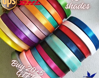 Könnte beinhalten: Ein Stapel von 45+ bunten Satinbandrollen. Das Band ist in einem Regenbogenmuster angeordnet. Der Text "Buy 20+5 Gift" ist auf dem Bild sichtbar.