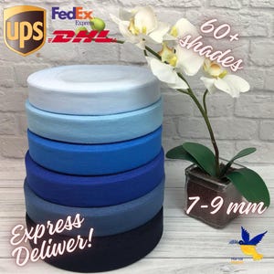 May include: A stack of blue ribbon rolls in various shades, from light to dark, with the text "60+ shades" and "7-9 mm". A white orchid plant is in the background. The text "Express Deliver!" is also visible.