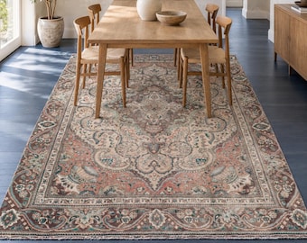May include: A large rectangular area rug featuring a complex, symmetrical pattern in muted shades of terracotta, sage green, slate blue, and cream. The design includes a central medallion surrounded by intricate floral and vine motifs with a border.