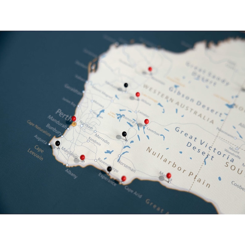 May include: A map of Western Australia with red and black push pins marking various locations. The map is on a dark blue background.