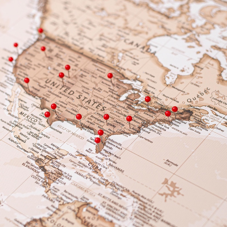 May include: A detailed map of North America, Central America, and the Caribbean, with red push pins marking various locations. The map is in sepia tones, highlighting the United States, Mexico, and Canada. The pins are evenly spaced across the map.