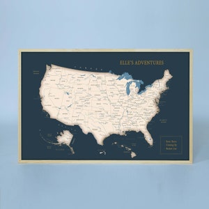 Puede incluir: Un mapa de los Estados Unidos en azul y blanco con un marco de madera. El mapa se titula "Elle's Adventures" y tiene una secci&oacute;n "Been There, Coming Up, Bucket List".